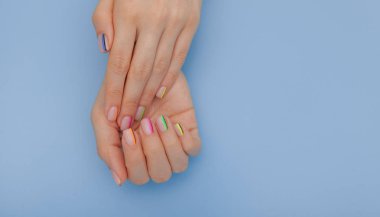 Şık trendy kadın manikür. Güzel genç kadının elleri mavi arka planda. Metin için alan