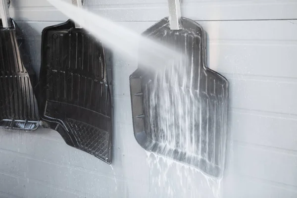 Car carpets washing with high pressure washer, close-up