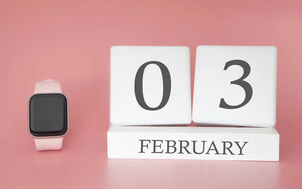 Modern Watch with cube calendar and date 03 february on pink background. Concept winter time vacation.