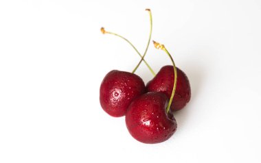Beyaz arka planda olgun kiraz, biraz su damlası, yakın plan..