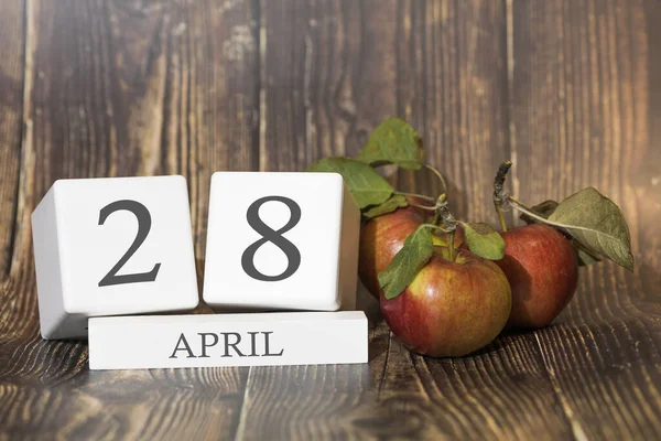 4月28日 月の28日 赤いリンゴと木製の背景にカレンダーキューブ ビジネスの概念と重要なイベント — ストック写真