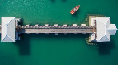Doğal açık mavi deniz deniz yüzen köprü ve tekne ile havadan görünümü. Anteni: Kıyı balıkçı tekneleri ve kum plaj boyunca otopark uzun kuyruk taksi tekneler.