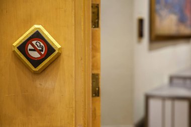 Ahşap duvarda sigara içme işareti yok. Ahşap zemindeki sigara içilmeyen beyaz tabela gezginin sigara içmediğinin farkında olduğunun bir işaretidir. - Direkte sigara içilmez tabelası