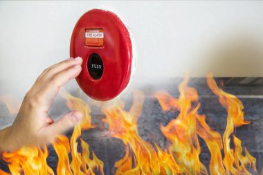 Adam elini yangın alarm El İstasyonu itmek için ulaşıyor. Yangın alarm anahtarı yeni fabrika binasında acil durum için arka plan olarak beyaz duvara çekerek adamın elini