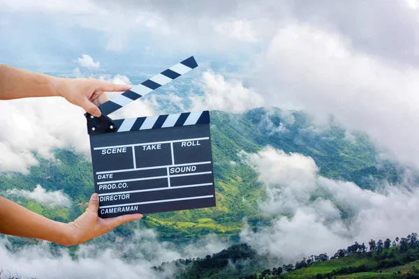 Man hands holding movie clapper.Film director concept.camera show viewfinder image catch motion in interview or broadcast wedding ceremony, catch feeling, hand hold a Film Slate with mountain and sky.