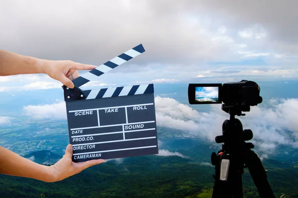 Man hands holding movie clapper.Film director concept.camera show viewfinder image catch motion in interview or broadcast wedding ceremony, catch feeling, hand hold a Film Slate with mountain and sky.