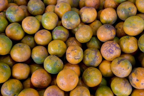 Shogun oranges. The skin slim soft sour flavors are good. Fresh oranges at a local farmers market . Tangerines as the background. Big bunch of ripe tangerines.