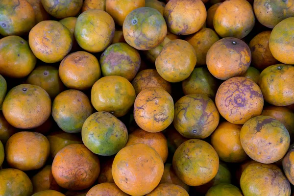 Shogun oranges. The skin slim soft sour flavors are good. Fresh oranges at a local farmers market . Tangerines as the background. Big bunch of ripe tangerines.