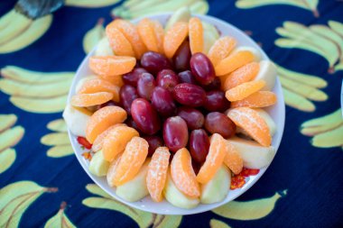 Üzümlü, portakallı, sağlıklı ve güzel meyve konseptli beyaz tabak. sanat yiyecekleri dekorasyonu. 