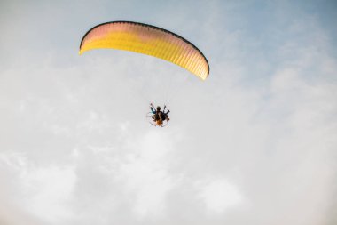 Paramotor silueti paramotor planör paraşüt ile gökyüzünde uçan gün batımında Gökyüzüne Uçan Macera adam aktif ekstrem spor pilotu. Gün batımında gökyüzünde uçan paramotor. 