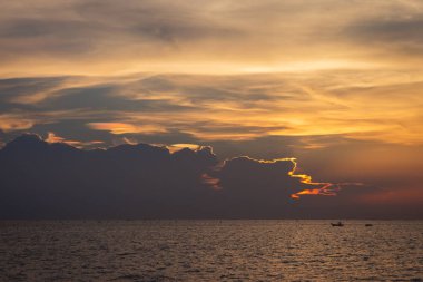 Deniz yüzeyinin altında büyük sarı güneş ile parlak gün batımı. denizde gündoğumu. Denizin üzerinde güzel bir gün batımı. Sahilde tropikal günbatımı.