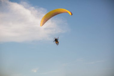 Paramotor silueti paramotor planör paraşüt ile gökyüzünde uçan gün batımında Gökyüzüne Uçan Macera adam aktif ekstrem spor pilotu. Gün batımında gökyüzünde uçan paramotor. 