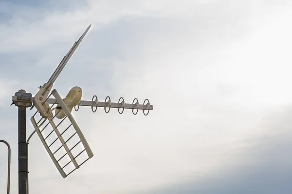 Television antennas with sky background. Analog television antenna on roof. Antennae for digital TV and radio reception. Mobile communication antennas at sunset.