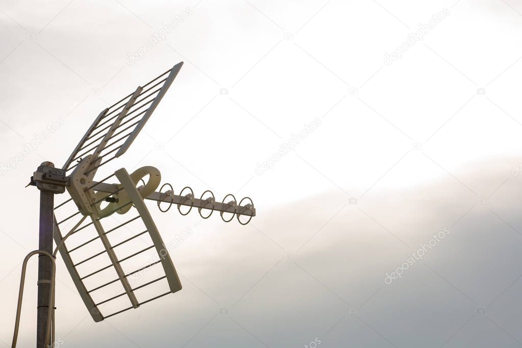 Television antennas with sky background. Analog television antenna on roof. Antennae for digital TV and radio reception. Mobile communication antennas at sunset.