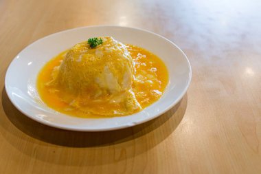 Pirinç üzerine Tay omleti. Kızarmış yumurta (omlet), beyaz plaka üzerinde kaşık ve çatal ile Pilav. Üst görünüm Tayland tarzı Omlet pirinç. Pirinç üzerine pastırma ve mantar ile Kremsi omlet.