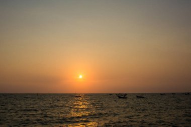 Deniz yüzeyinin altında büyük sarı güneş ile parlak gün batımı. denizde gündoğumu. Denizin üzerinde güzel bir gün batımı. Sahilde tropikal günbatımı.