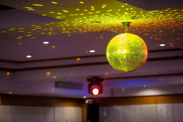 Disco ball with bright rays, night party background photo . party lights disco ball . Party disco ball with stars in nightclub with striped walls lit by spotlight, nightlife entertainment industry.