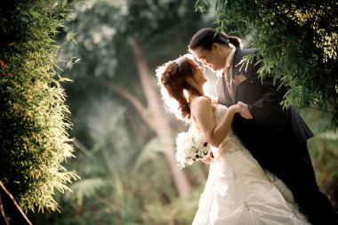 Bir yaz üzerinde romantik anları outsides zevk düğün çift. Düğünlerinde mutlu bir gelin ve damat. Güzel genç düğün çift doğada outsides. Vanlentine background için fotoğraf