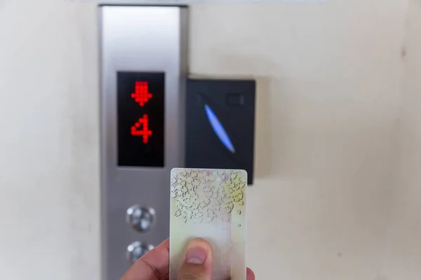 securing lift or elevator access control. elevator access control, Hand holding a key card to unlock elevator floor before up or down.