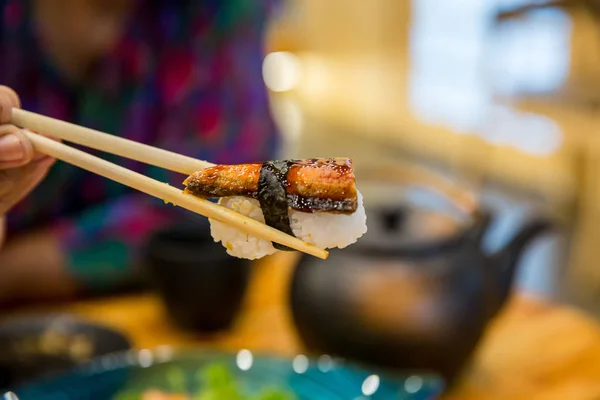 Cierre Los Palillos Sostenga Sushi Anguila Agua Dulce Parrilla Comida —  Fotos de Stock