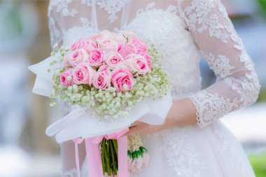 Çiçekli gelin elleri. gelinin elinde buket, kadın düğün töreni öncesi hazırlanıyor .