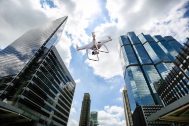 Yüksek çözünürlüklü dijital kamera ile Drone şehir üzerinde uçan . Yükseltilmiş iniş takımları ve bir kamera ile uçan bir multi-copter bir havadan görünümü . Dijital kameralı İhA drone quadcopter.
