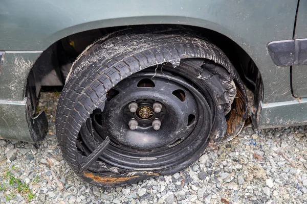 Destroyed blown out tire with exploded, shredded and damaged tire on a modern automobile. damaged truck rubber after tire explosion at high speed. Damaged flat tires: old car.