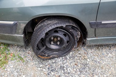Modern bir otomobilin lastiği patlamış, parçalanmış ve hasar görmüş lastiklerle patlamış lastik yok olmuş. yüksek hızda lastik patlaması ndan sonra hasarlı kamyon kauçuk. Hasarlı düz lastikler: eski araba.