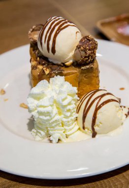 vanilyalı dondurma ve kırbaçlama krema ile bal tost beyaz çanak çikolata sosu ile tepesinde. tatlılar ekmek ve tatlı. şeker yüksek kalori. arka plan, duvar kağıdı ve kopyalama alanı için görüntü.