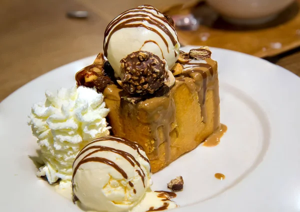 vanilyalı dondurma ve kırbaçlama krema ile bal tost beyaz çanak çikolata sosu ile tepesinde. tatlılar ekmek ve tatlı. şeker yüksek kalori. arka plan, duvar kağıdı ve kopyalama alanı için görüntü.