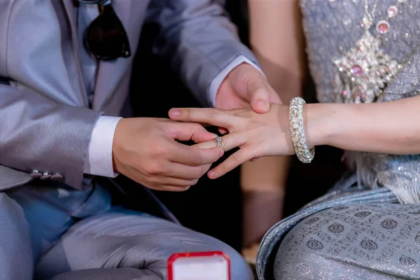 Nikah yüzükleri. Ona evlilik yüzüğü tak. Damat koymak yukarıya gelin yüzüğü kapatın. Tay düğün töreni ve Tay düğün dekorasyon. 