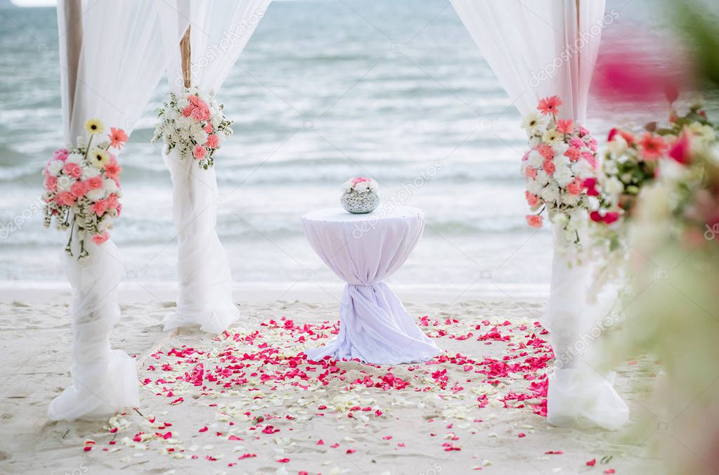 Romantic wedding ceremony on the beach. Wedding setting on the beach. Flowers wedding ceremony by the sea. Beach wedding interior decor.