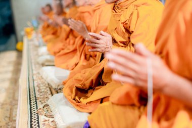 Pray of monks on ceremony of buddhist in Thailand. Many Buddha monk sit on the red carpet prepare to pray and doing buddhist ceremony. clipart