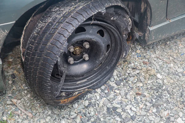 Destroyed blown out tire with exploded, shredded and damaged tire on a modern automobile. damaged truck rubber after tire explosion at high speed. Damaged flat tires: old car.