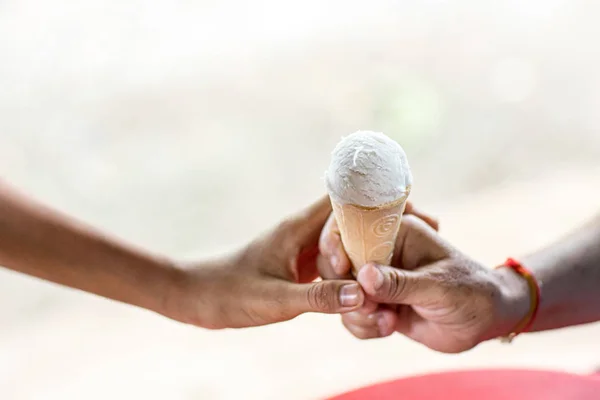 手は子供たちにアイスクリームを与えます アイスクリームを食べる子供たちとアイスクリームコーンを共有します 写真コンセプト共有時のみリアルな写真コンセプト — ストック写真