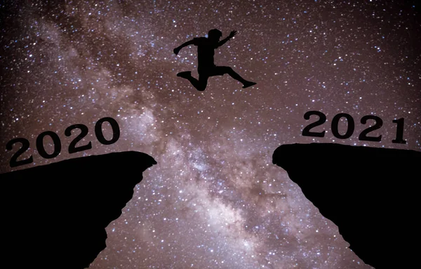 一个年轻人在2020年至2021年间 带着星星跳过夜空 穿过山丘轮廓的缝隙 看到了夜晚五彩斑斓的天空 2021年新年快乐 银河路 — 图库照片