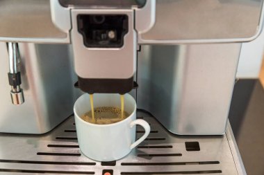 Kendi kendine hizmet eden kahve makineleri otelde, spor kulübünde ya da ofiste sürekli kaliteli kahve sunuyor. Espresso kapuçino kahve makinesi masanın üstünde..