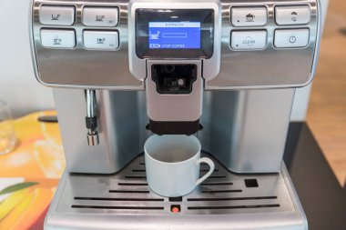 Kendi kendine hizmet eden kahve makineleri otelde, spor kulübünde ya da ofiste sürekli kaliteli kahve sunuyor. Espresso kapuçino kahve makinesi masanın üstünde..