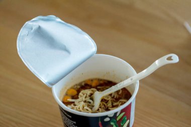 Sıcak erişte kupası. Erişte fincanı hazır. Plastik çatalla Anında Erişte yemek. Atıştırmalık erişteler popüler yemekleri yiyor..