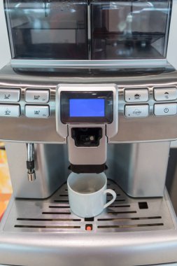 Kendi kendine hizmet eden kahve makineleri otelde, spor kulübünde ya da ofiste sürekli kaliteli kahve sunuyor. Espresso kapuçino kahve makinesi masanın üstünde..