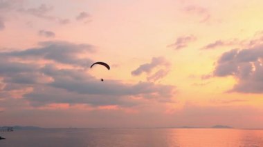 Mavi gökyüzünde uçan adam ve muhteşem plajda Paramotor Red Fite, ekstrem aktivite limanı. Özgürlüğü kuşlar gibi hisset. konsept insan fizyolojisinin sınırlarını aşar.