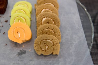 Ahşap tabakta reçel. Yakın plan. Çikolatalı reçel rulosuna odaklan. Yeşil çay, kiraz ve limon aromalı Yuzu. İsviçre usulü fasulye ezmeli Ichiroku turtası, Japon tatlıları..