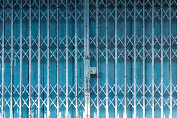 Folding metal house door, Old metallic, Iron door. Blue stretched slide steel airy door at outside with steel sheet lock and dense iron door at inside ,full metal folding Chinese gate.
