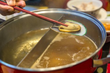 Sukiyaki demliğinde et ve sebze kaynatmak ve buharda pişirmek, sağlıklı olarak haşlanmış yemeği seçmek ve kızarmış yiyeceklerden kaçınmak kavram. Seçici odaklanma Shabu Shabu ve Sukiyaki, Japon yemekleri.