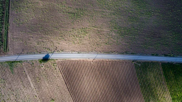 農地と未舗装道路の空中ビューから平行線 砂利道のドローン写真2つのフィールドを分割します 農業分野 途中で道路上から — ストック写真