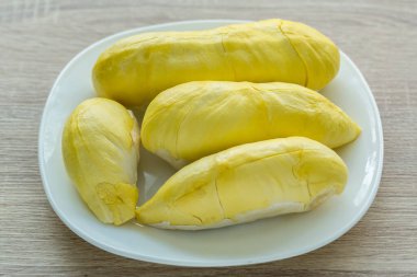 Beyaz bir tabağa yerleştirilmiş taze Durian meyvesi. Meyvelerin kralı Durian. Sarı renk beyaz tabakta. Tatlı tatlı ya da Tayland 'da atıştırmalık için olgun durian tropikal meyve yazı 