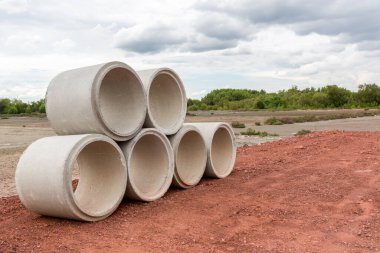 İnşaat alanındaki beton drenaj borusu. İnşaat için yığılmış beton drenaj boruları. Ana yolun yakınındaki inşaat alanında beton drenaj borusu.