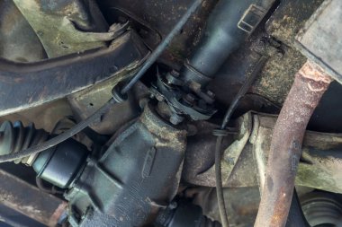 Garajdaki eski arabanın arka tekerlek dingilinin altında tamir kirli. Araç şaftı güç iletimi dingil araba tekerleği