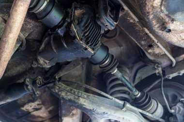 Garajdaki eski arabanın arka tekerlek dingilinin altında tamir kirli. Araç şaftı güç iletimi dingil araba tekerleği