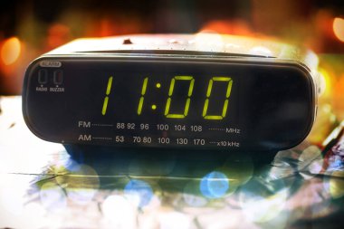 Siyah dijital alarmlı radyo saati. Kalkma zamanını gösteriyor. Dijital saat 11: 00 'i gösteriyor. Dijital radyo saati, saat 11: 00' i gösteriyor.